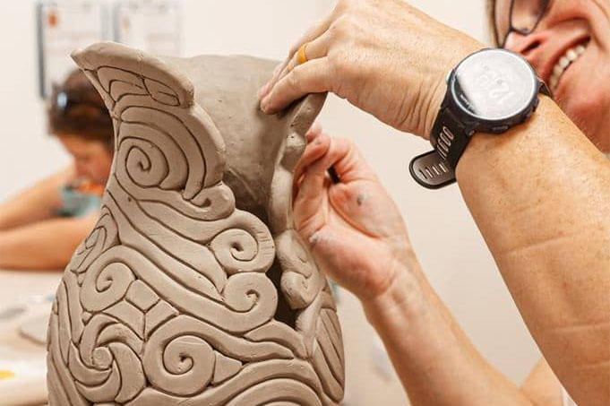 A potter at the wheel, just finished centering their clay