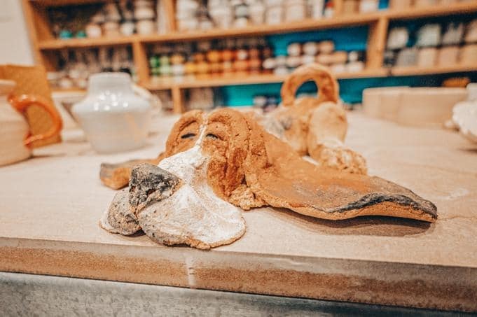 A potter at the wheel, just finished centering their clay